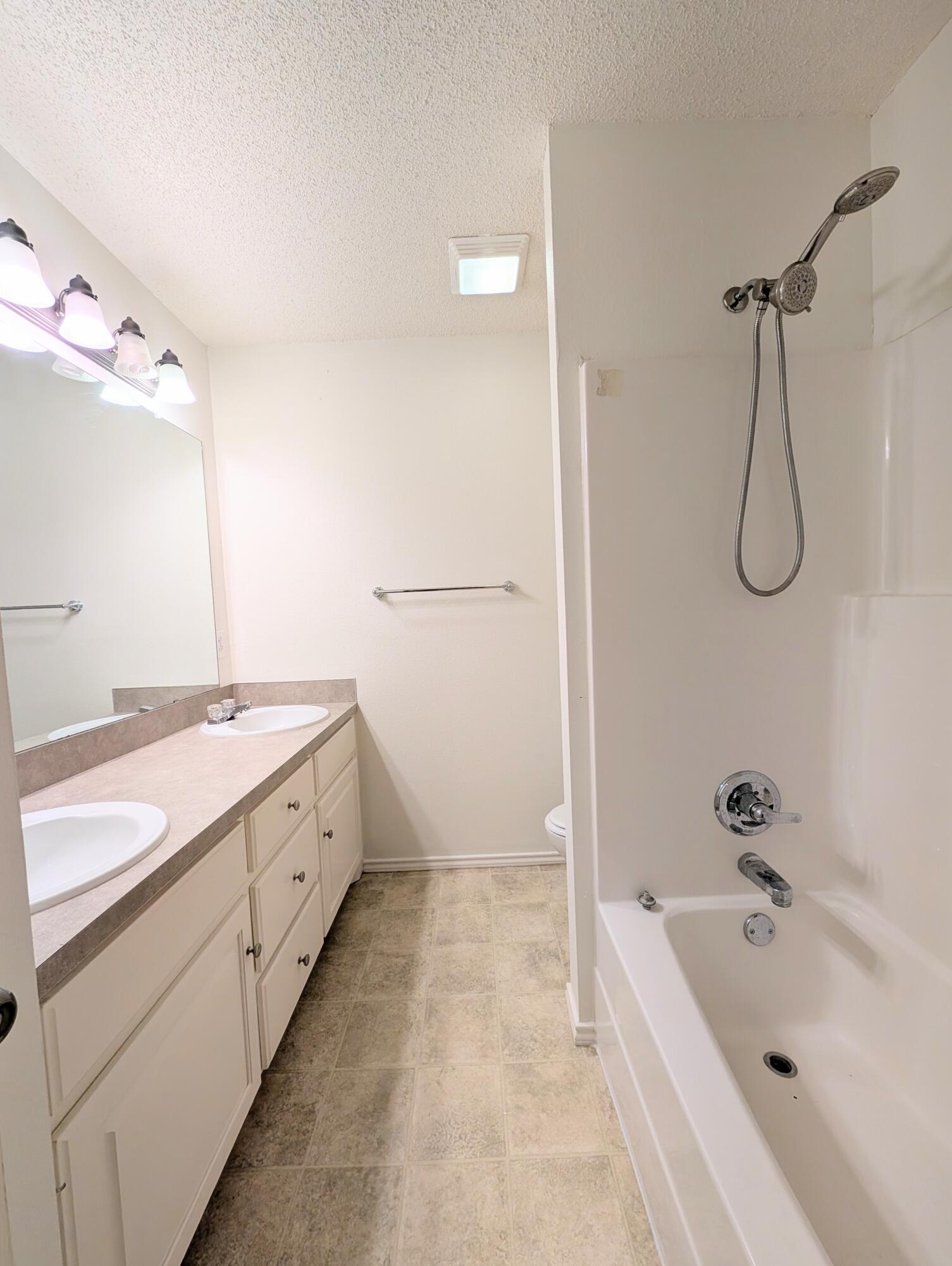 2417 87th Street, Unit B Lubbock, TX 79423 - Photo 10 of 11 a bathroom with a tub sink and mirror