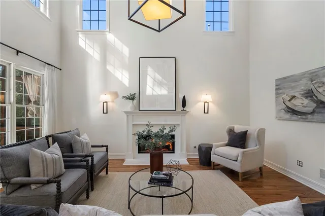 a living room with furniture a fireplace and a floor to ceiling window