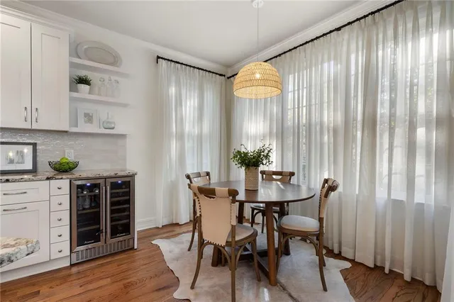 a kitchen with stainless steel appliances kitchen island granite countertop a refrigerator a stove a sink dishwasher a oven with white cabinets and wooden floor