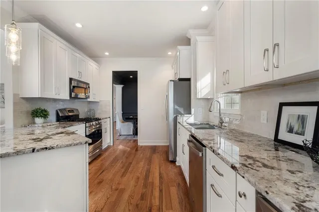 a bedroom with a large bed chandelier and a window