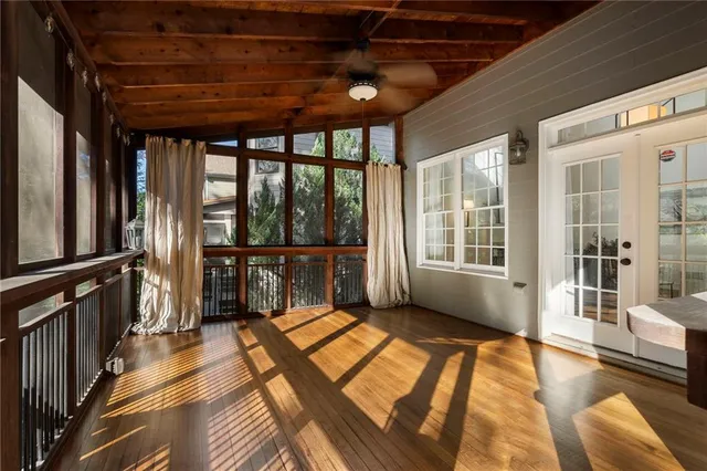 an empty room with a window and a chandelier fan