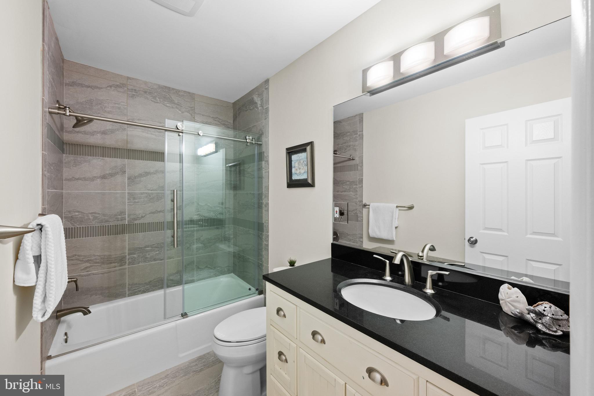 3529 Yuma Street Northwest Washington, DC 20008 - Photo 22 of 46 a bathroom with a granite countertop sink toilet mirror and bathtub