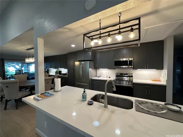 a kitchen with stainless steel appliances a sink a stove and chairs