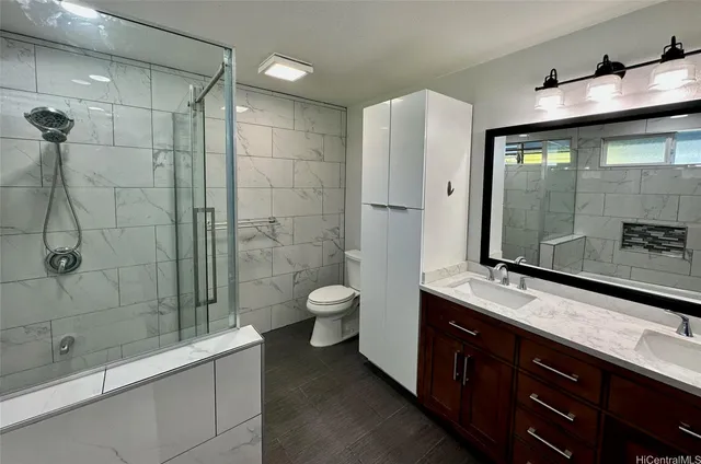 a bathroom with a double vanity sink toilet and shower