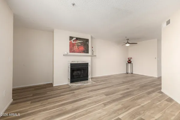 a view of an empty room with a fireplace and a window