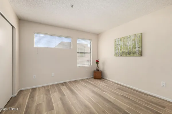a view of empty room with wooden floor and fan