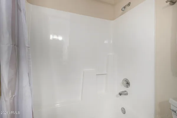 a view of an empty room with closet and a window