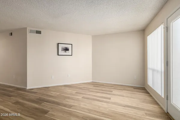 a view of empty room with fireplace and wooden floor