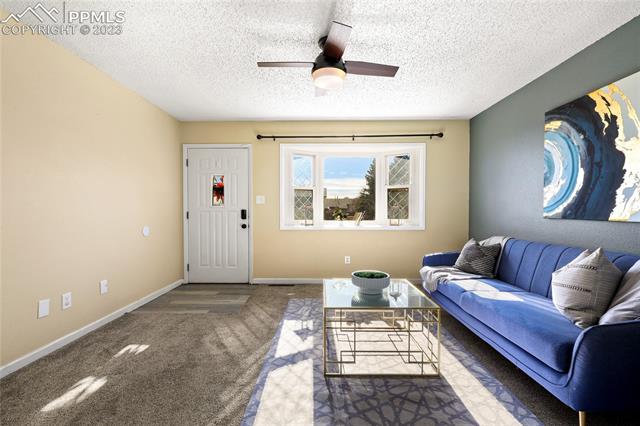 6786 Dale Road Colorado Springs, CO 80915 - Photo 1 of 23 Front Entry into the vaulted Living Room with neutral carpet and lighted ceiling fan