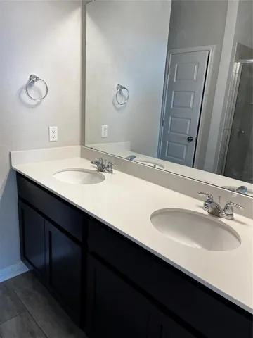 a bathroom with a double vanity sink and a mirror