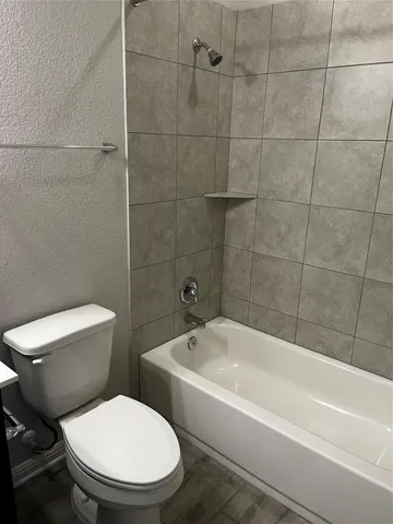 a white toilet sitting next to a bathtub