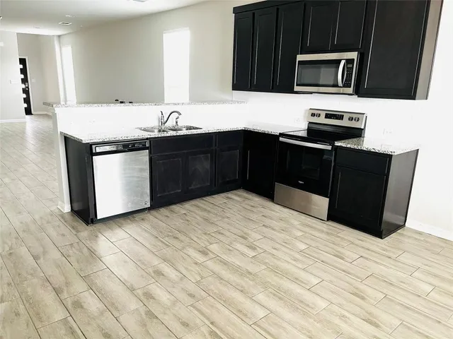 a kitchen with stainless steel appliances granite countertop a sink and a stove