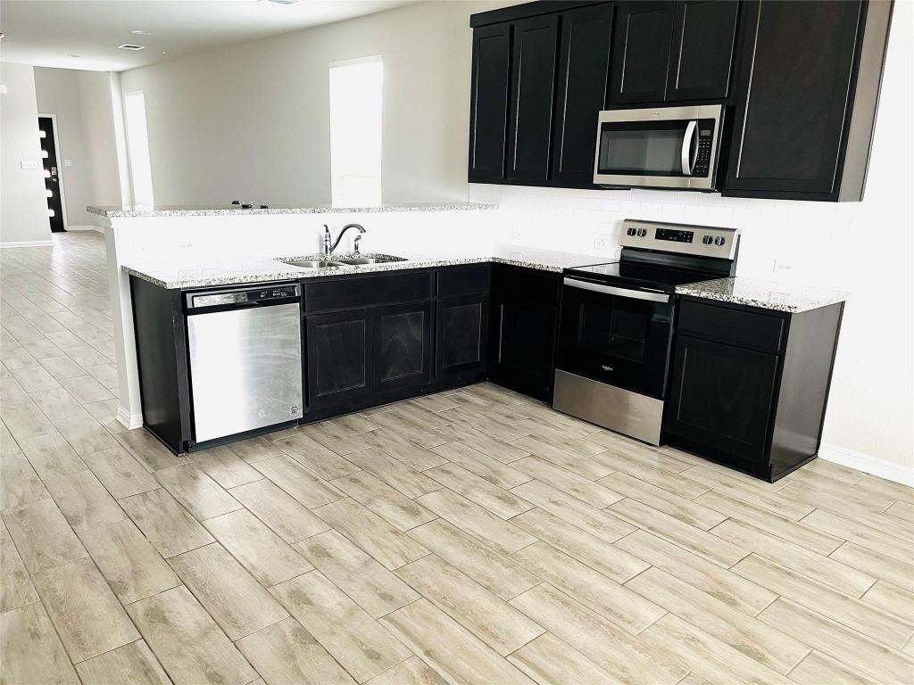 110 Trellis Boulevard Leander, TX 78641 - Photo 8 of 8 a kitchen with stainless steel appliances granite countertop a sink and a stove