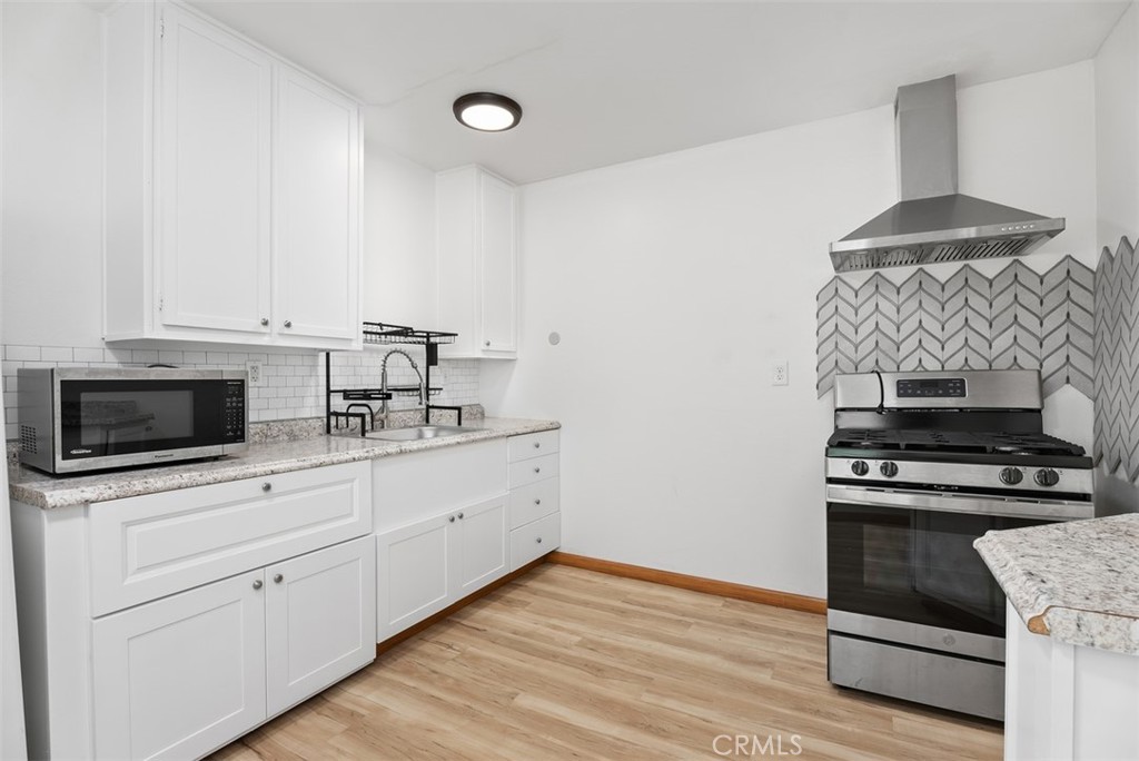 156 West Escalones San Clemente, CA 92672 - Photo 11 of 39 a kitchen with granite countertop a stove and a microwave