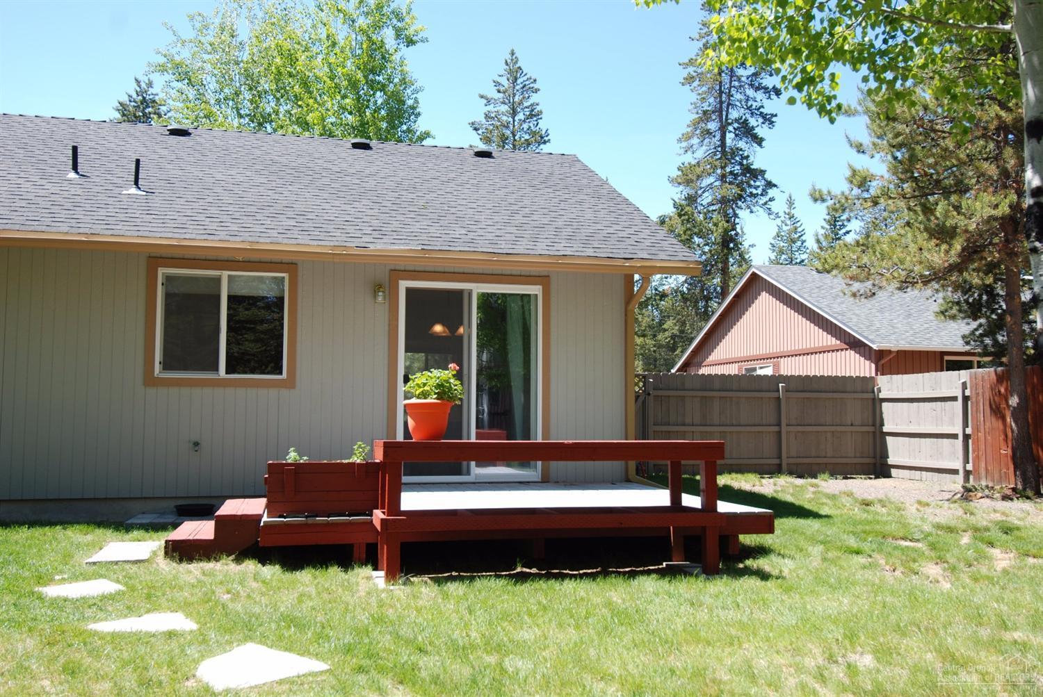 55726 Snow Goose Road Bend, OR 97707 - Photo 16 of 25 a backyard of a house with wooden fence and a bench