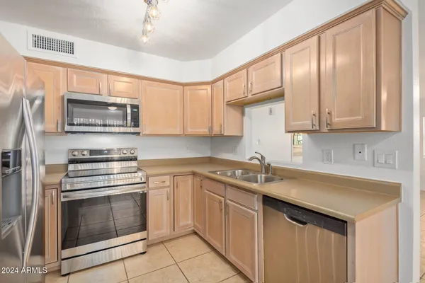 a kitchen with granite countertop a stove top oven microwave and cabinets