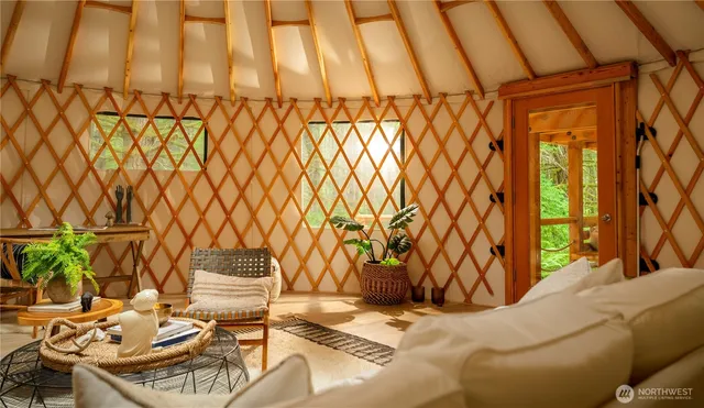 a yard with yellow house and wooden fence