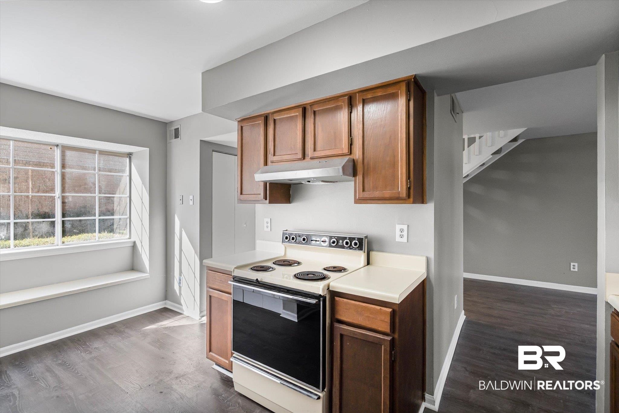 6701 Dickens Ferry Road, Unit 100 Mobile, AL 36608 - Photo 4 of 24 Kitchen featuring range with electric cooktop, light countertops, dark wood-style flooring, and under cabinet range hood