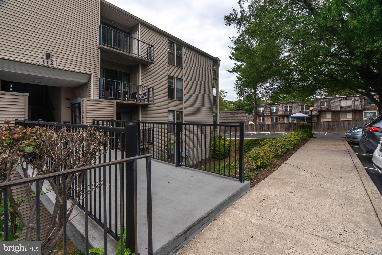 112 Duvall Lane, Unit 304 Gaithersburg, MD 20877 - Photo 3 of 27 a view of a house with a small yard and a large tree