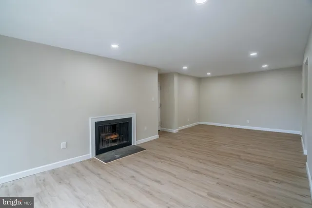 an empty room with wooden floor and fireplace