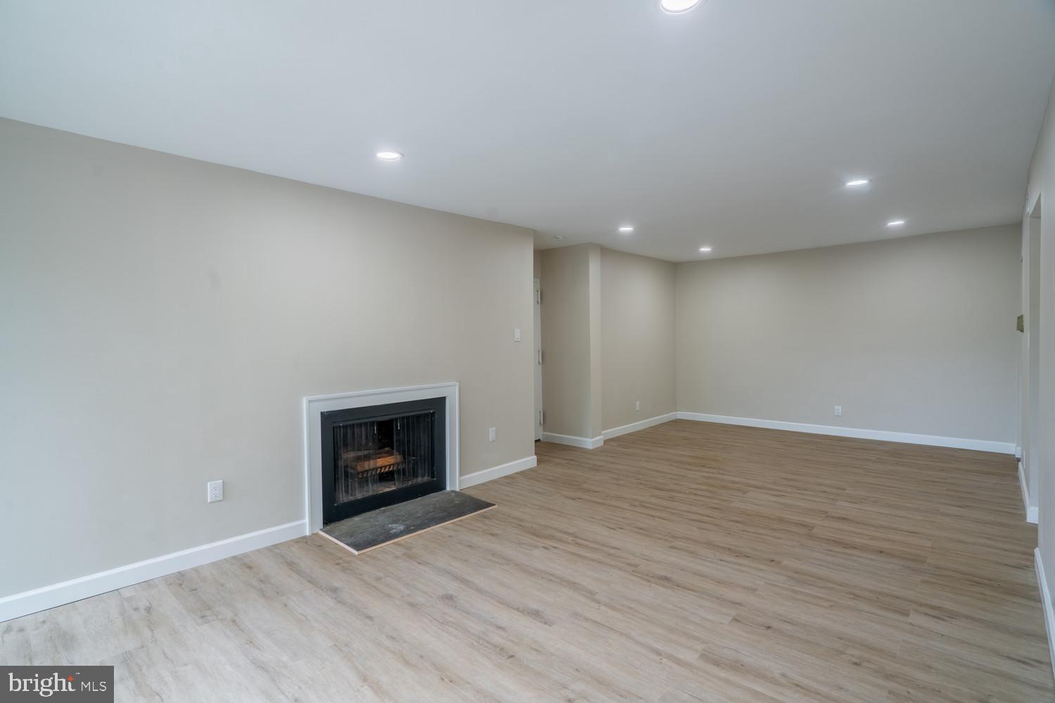 112 Duvall Lane, Unit 304 Gaithersburg, MD 20877 - Photo 9 of 27 an empty room with wooden floor and fireplace