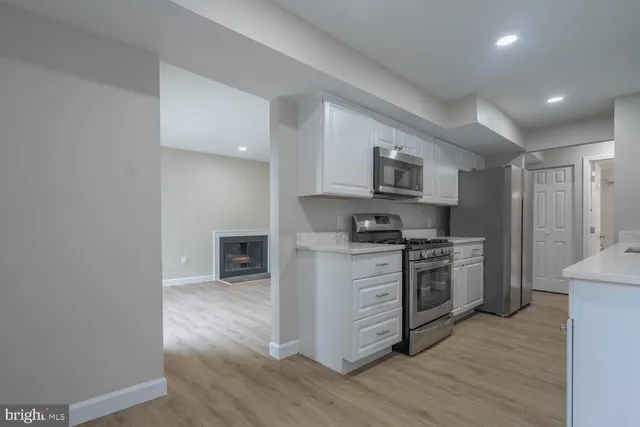 a kitchen with granite countertop a refrigerator and a stove top oven