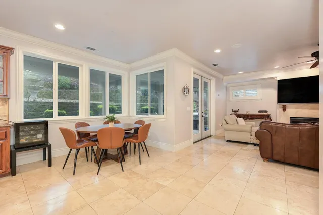 a kitchen with stainless steel appliances kitchen island granite countertop a table chairs sink and cabinets