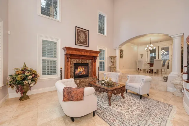 a living room with furniture a fireplace and a chandelier