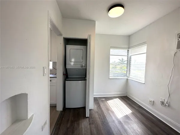 a view of utility room and bedroom with wooden floor