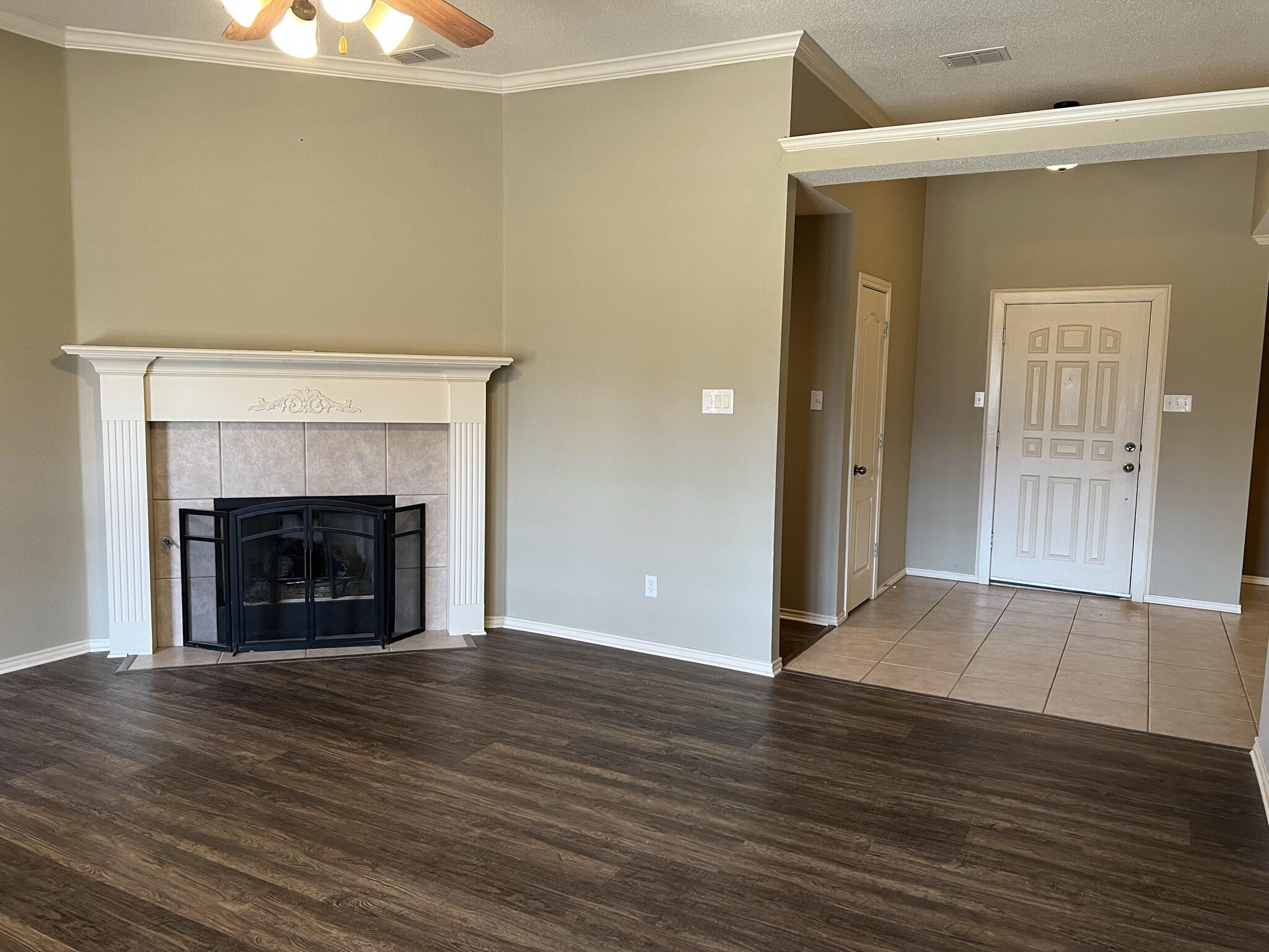 5027 Itasca Street Lubbock, TX 79416 - Photo 2 of 22 an empty room with wooden floor and fireplace