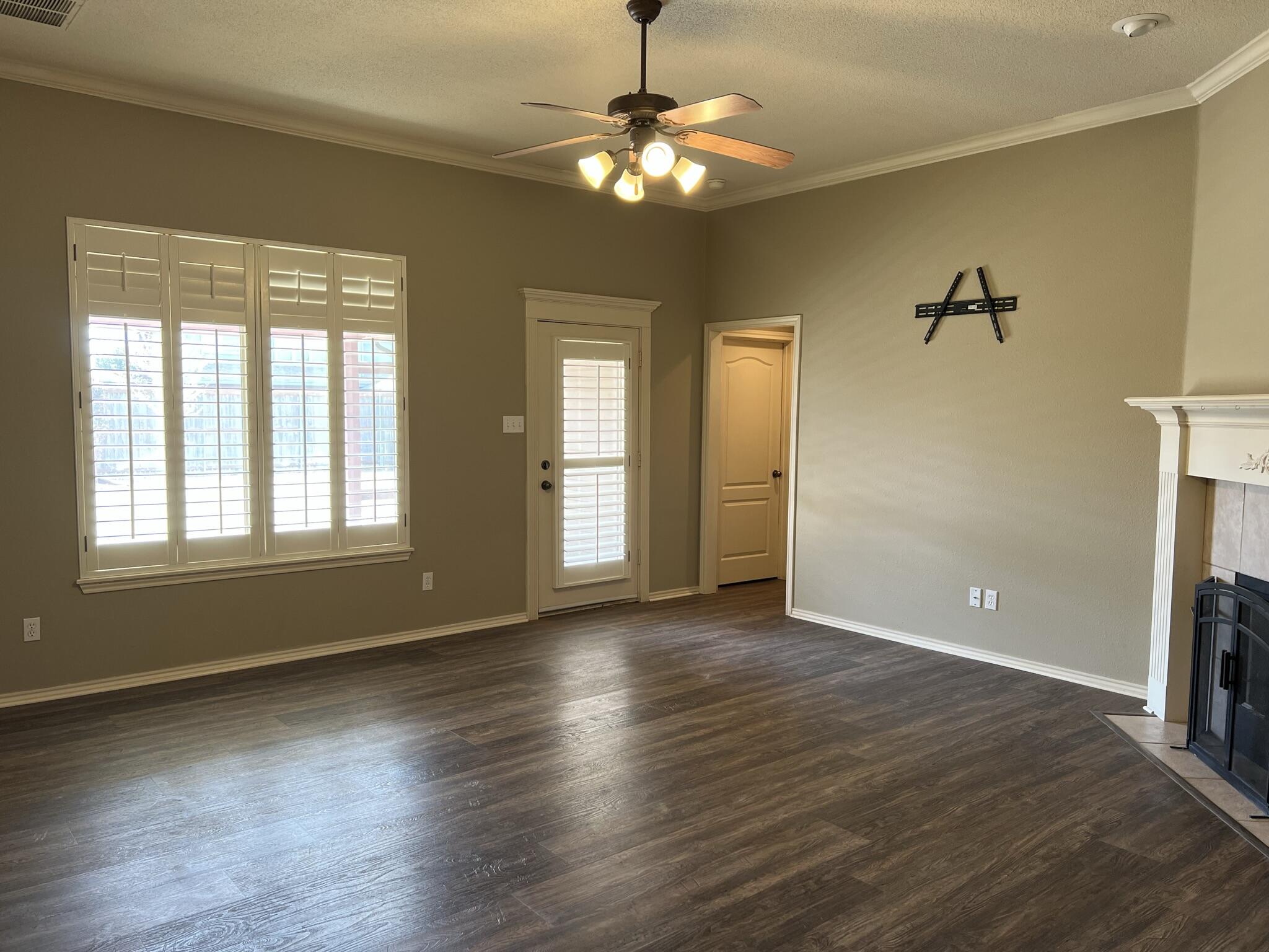 5027 Itasca Street Lubbock, TX 79416 - Photo 3 of 22 a view of an empty room with a window and wooden floor