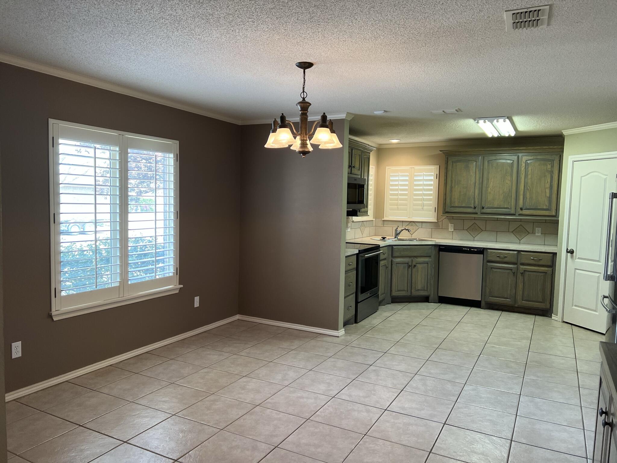 5027 Itasca Street Lubbock, TX 79416 - Photo 6 of 22 a kitchen with a sink cabinets and window