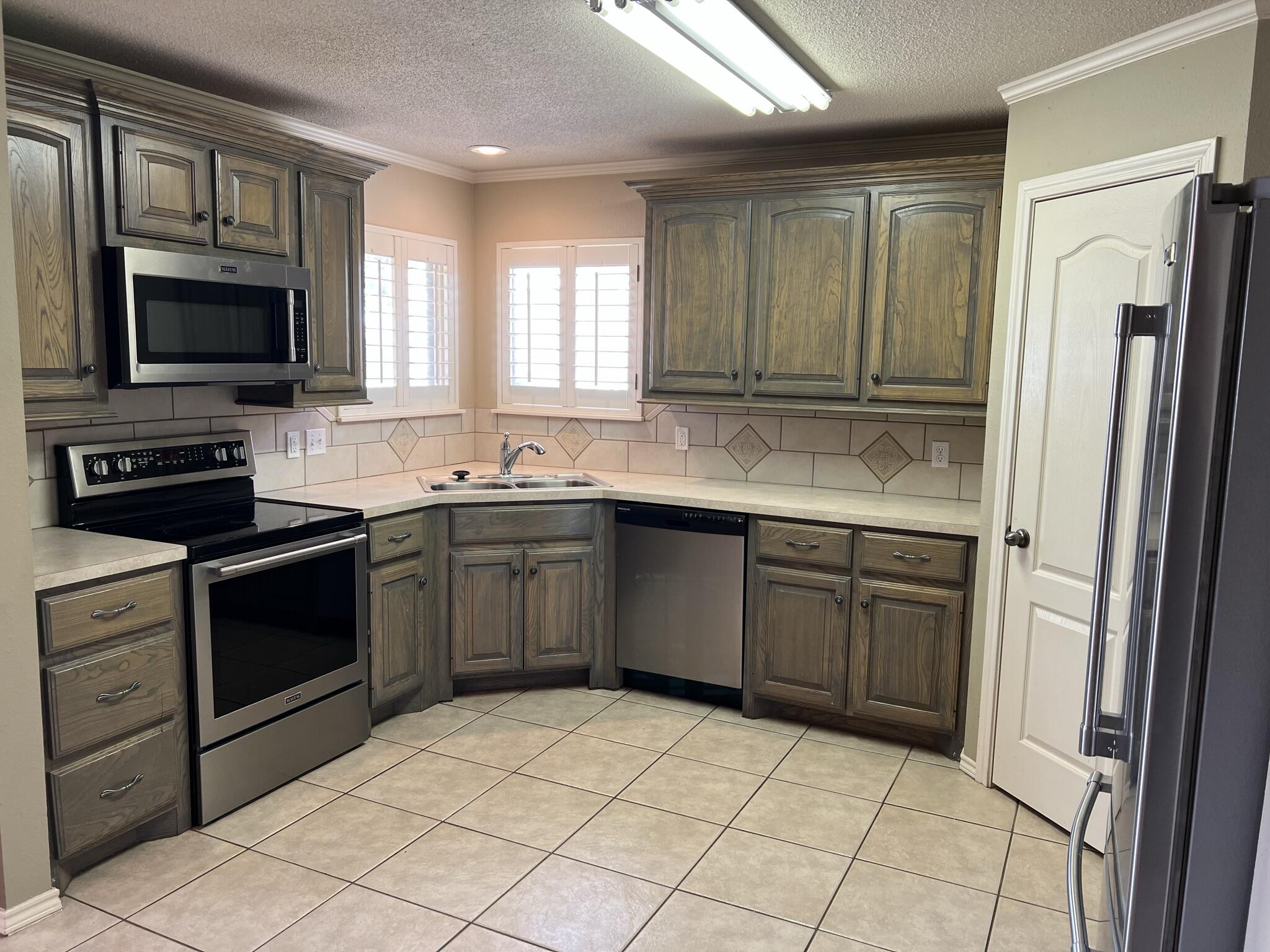 5027 Itasca Street Lubbock, TX 79416 - Photo 7 of 22 a kitchen with a sink stove and refrigerator