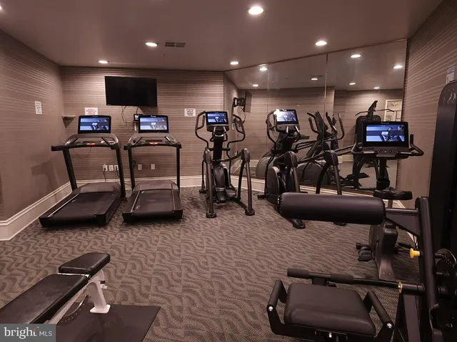 a room with gym equipment and a flat screen tv