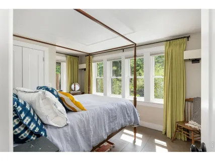 a bedroom with a bed and a large window