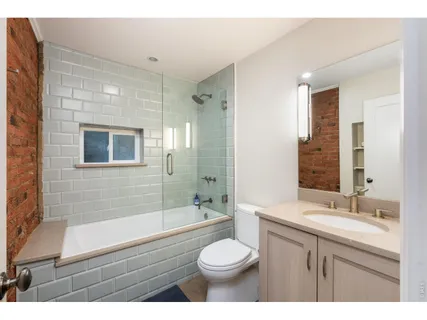 a bathroom with a sink a toilet a mirror and shower