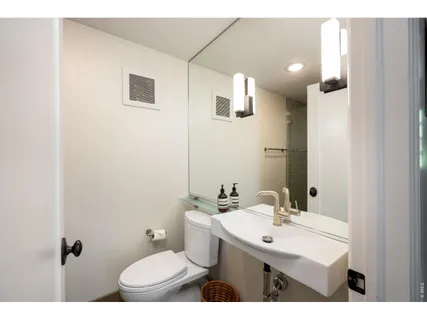 a bathroom with a sink mirror and toilet