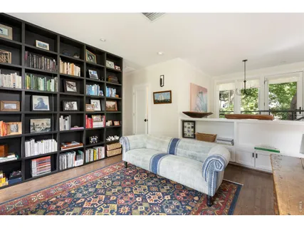 a living room with furniture and a book shelf