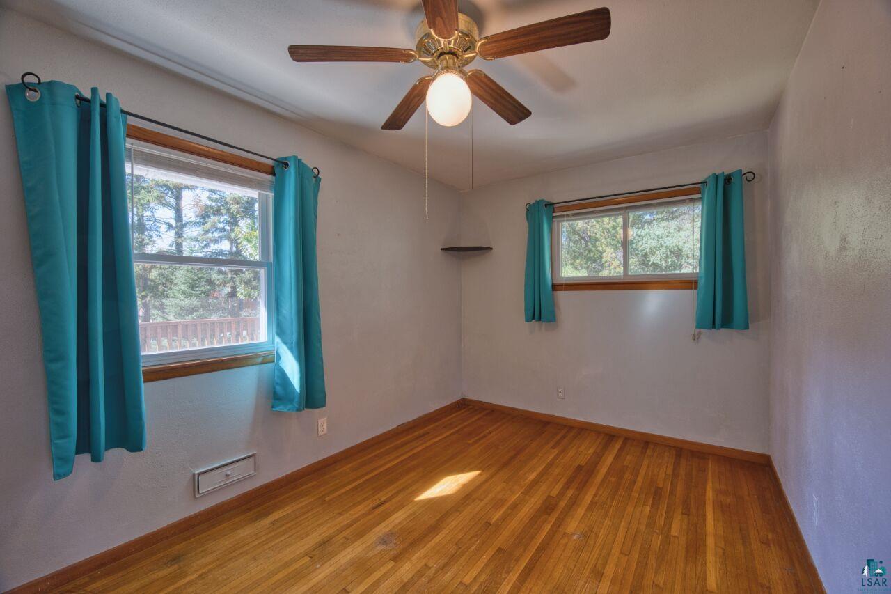 5316 Highway 110 Aurora, MN 55705 - Photo 13 of 35 Empty room with hardwood / wood-style floors, a ceiling fan, and a textured wall
