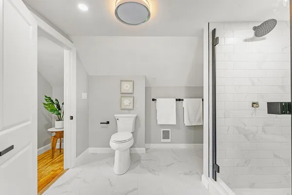 a bathroom with a granite countertop sink a toilet and shower