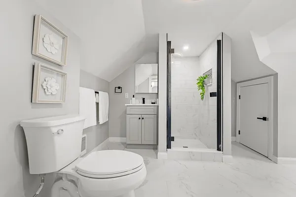 a bathroom with a toilet a sink and shower