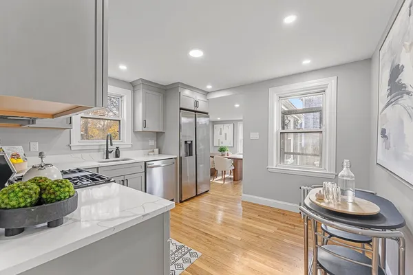 a kitchen with sink refrigerator dining table and chairs