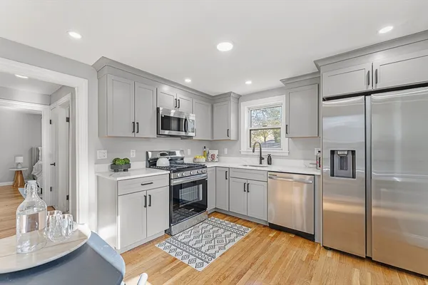 a kitchen with white cabinets and stainless steel appliances