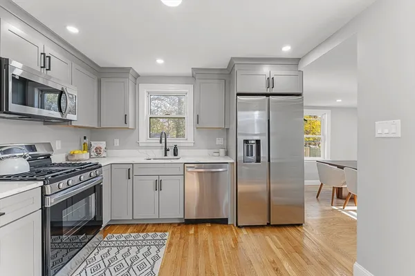 a kitchen with stainless steel appliances a refrigerator sink and microwave