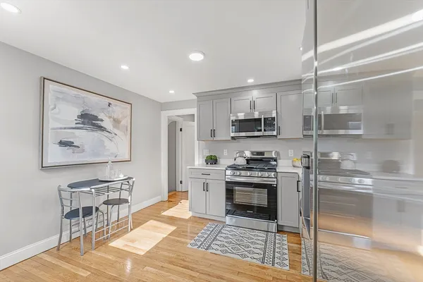 a kitchen with stainless steel appliances granite countertop a stove top oven a sink and a refrigerator
