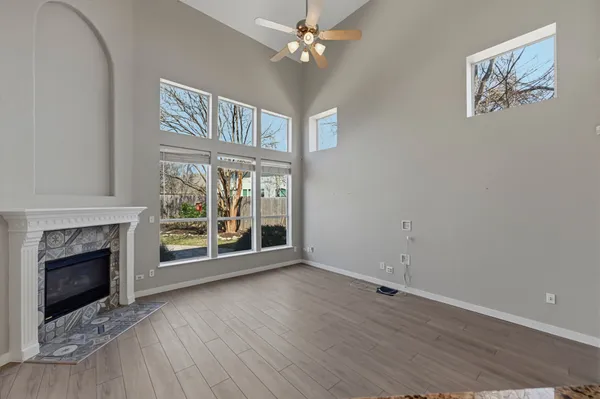 wooden floor fireplace and windows in an empty room