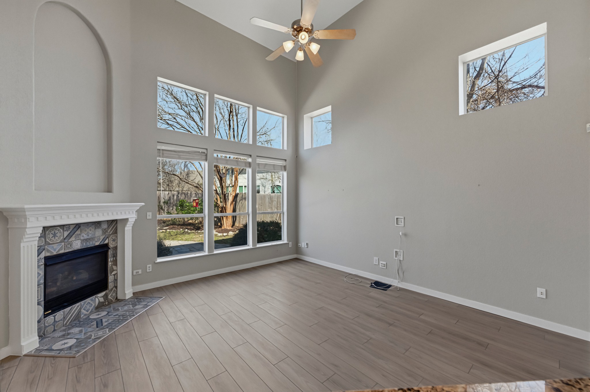 6810 Poncha Pass Austin, TX 78736 - Photo 12 of 35 wooden floor fireplace and windows in an empty room