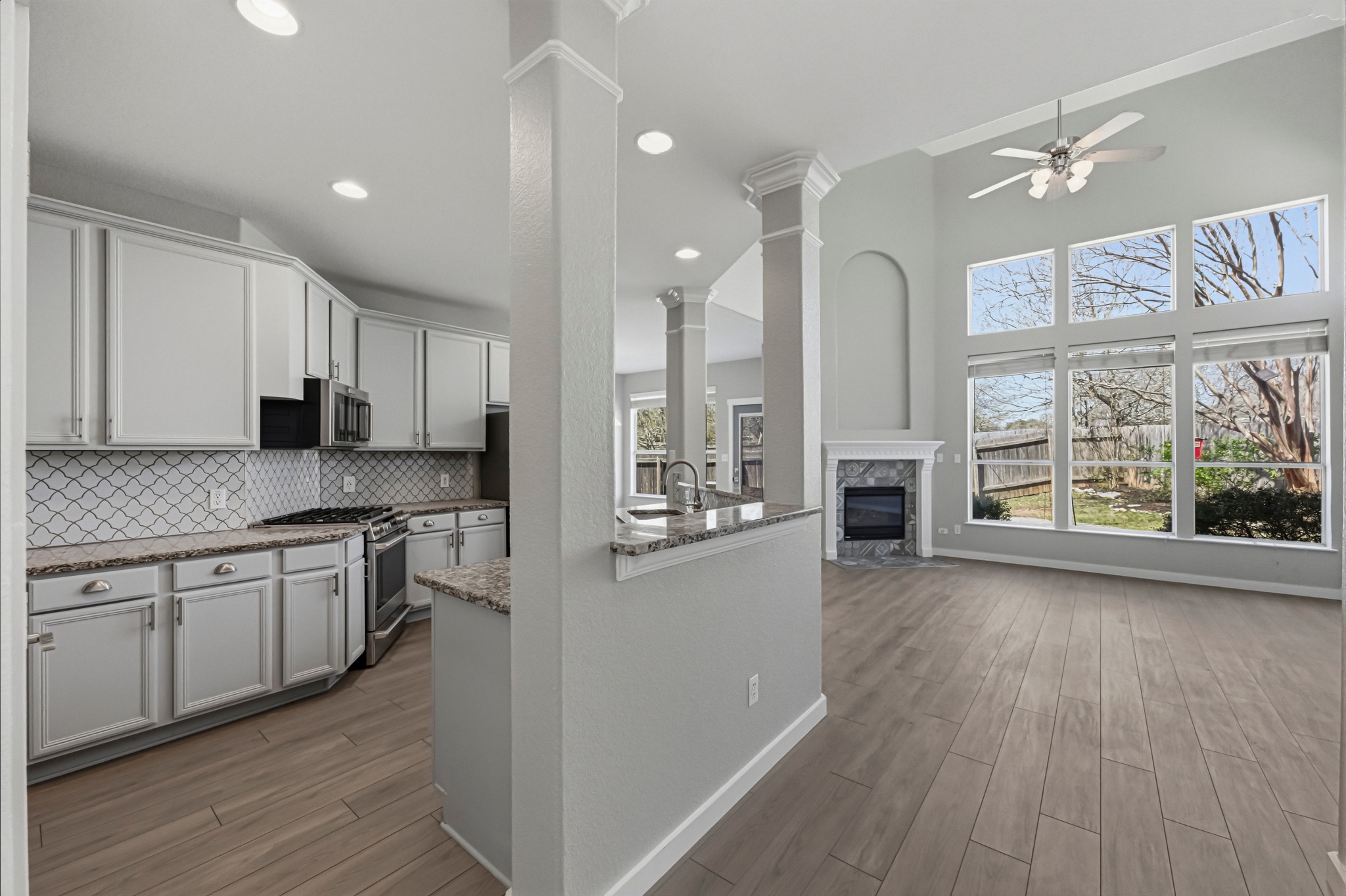 6810 Poncha Pass Austin, TX 78736 - Photo 13 of 35 a large kitchen with stainless steel appliances granite countertop a stove a refrigerator a sink and white cabinets with wooden floor