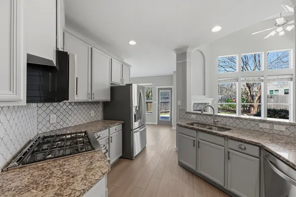 a kitchen with stainless steel appliances granite countertop a stove a sink and a refrigerator