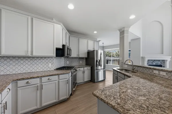 a kitchen with stainless steel appliances granite countertop a sink stove microwave and refrigerator